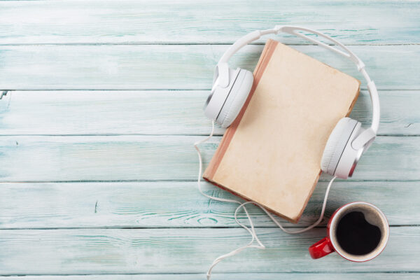 Audio book concept. Headphones, coffee and book